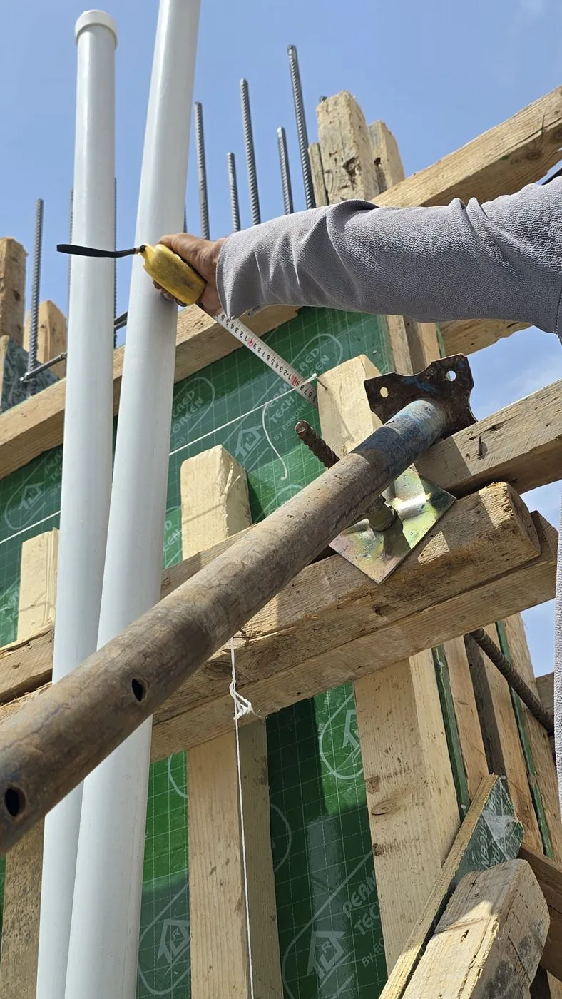 مهندس يقيس استقامة شدة عمود بالشريط والخيط قبل الصب في فيلا بحي العارض